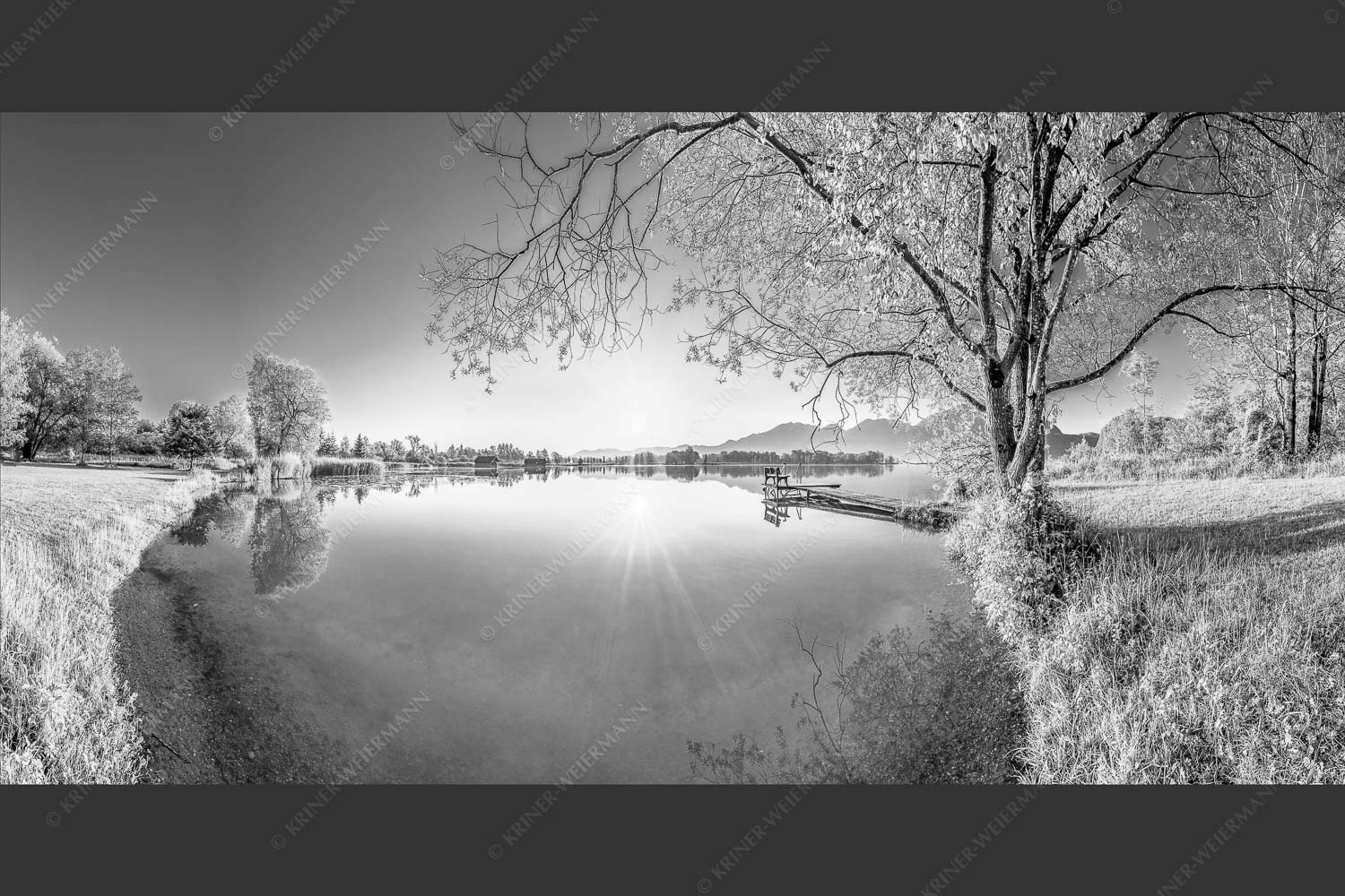 Blick über den Kochelsee bei Schlehdorf in den Sonnenaufgang - Die Sonne geht immer wieder auf II 2:1 sw -- Bootssteg am Kochelsee - mehr Infos bei www.Kriner-Weiermann.de
