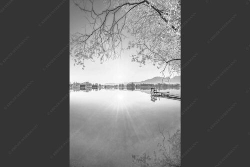 Blick über den Kochelsee bei Schlehdorf in den Sonnenaufgang - Die Sonne geht immer wieder auf II 2:3 sw -- Bootssteg am Kochelsee - mehr Infos bei www.Kriner-Weiermann.de
