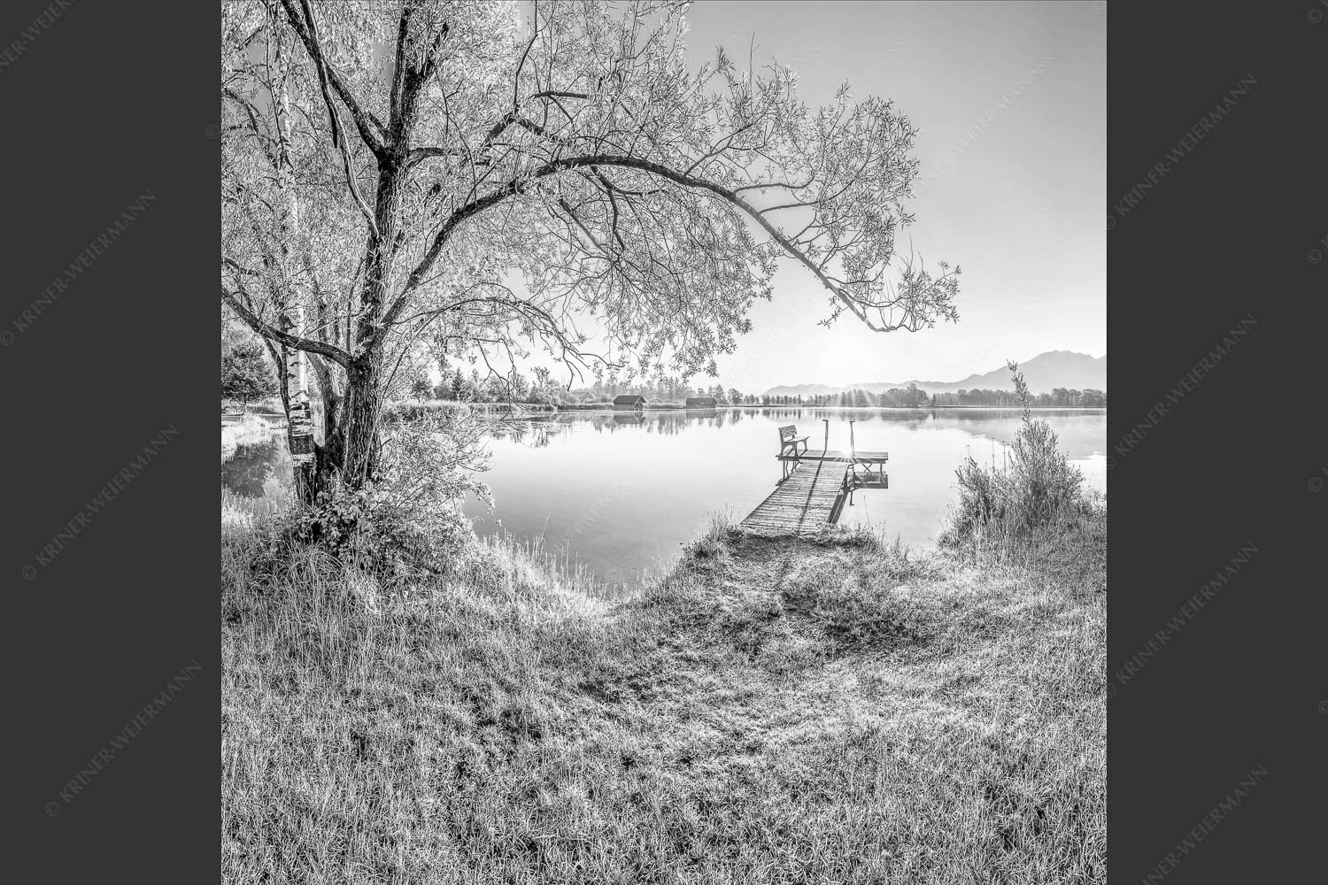 Blick über den Kochelsee bei Schlehdorf in den Sonnenaufgang - Die Sonne geht immer wieder auf III 1:1 sw -- Bootssteg mit Bank am Kochelsee - mehr Infos bei www.Kriner-Weiermann.de