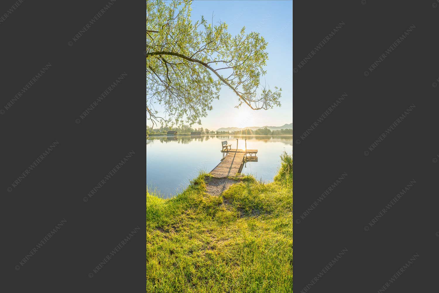 Blick über den Kochelsee bei Schlehdorf in den Sonnenaufgang - Die Sonne geht immer wieder auf III 1:2 -- Bootssteg mit Bank am Kochelsee - mehr Infos bei www.Kriner-Weiermann.de