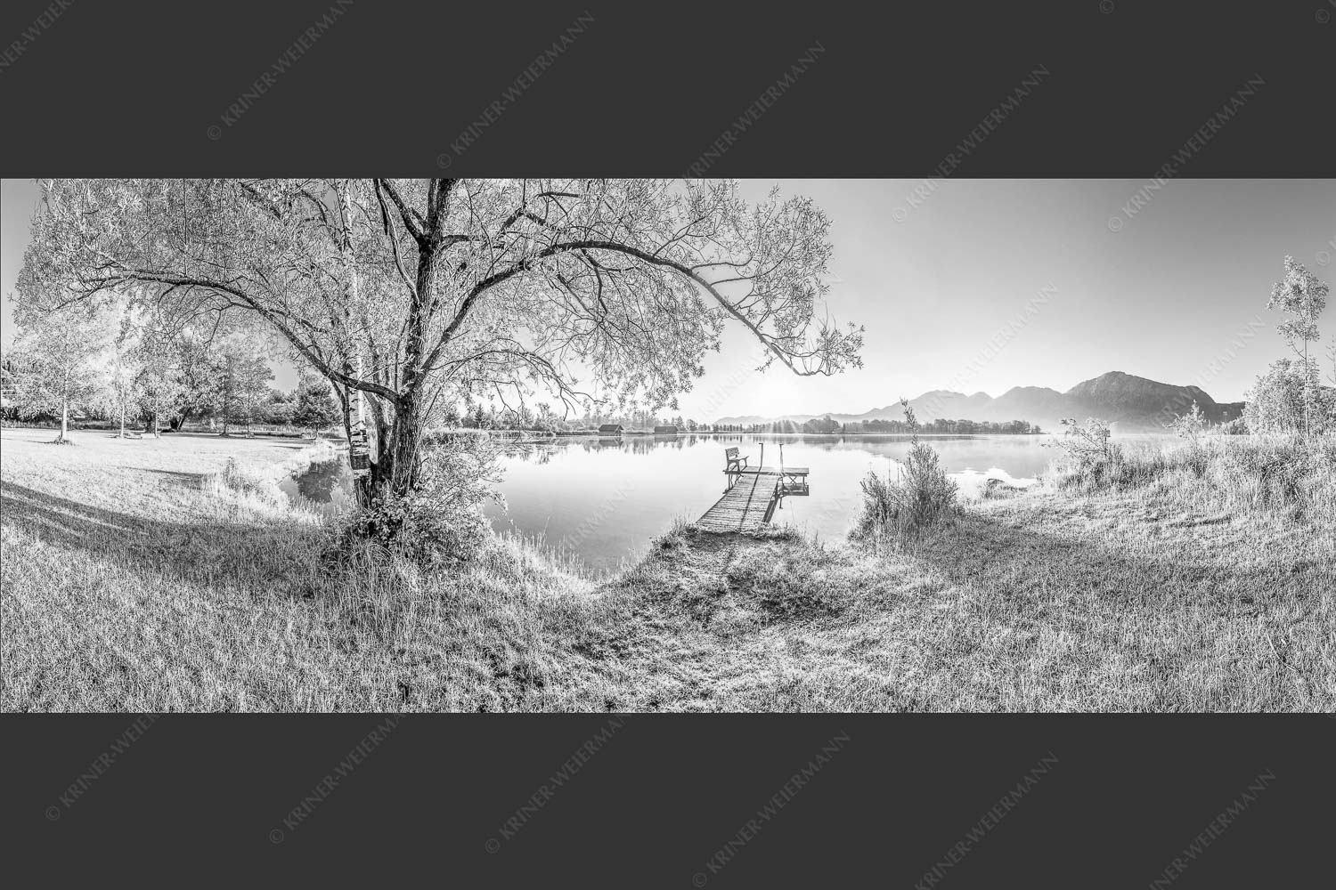 Blick über den Kochelsee bei Schlehdorf in den Sonnenaufgang - Die Sonne geht immer wieder auf III 2,5:1 sw -- Bootssteg mit Bank am Kochelsee - mehr Infos bei www.Kriner-Weiermann.de