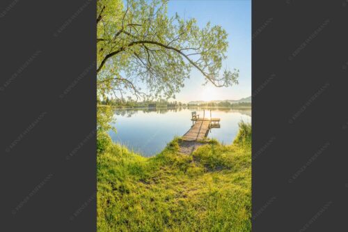 Blick über den Kochelsee bei Schlehdorf in den Sonnenaufgang - Die Sonne geht immer wieder auf III 2:3  -- Bootssteg mit Bank am Kochelsee - mehr Infos bei www.Kriner-Weiermann.de