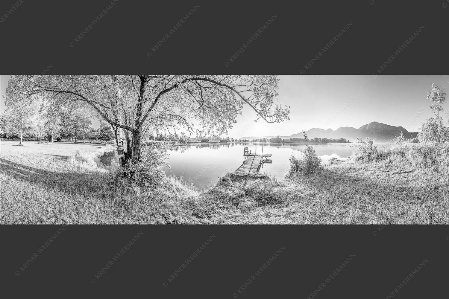 Blick über den Kochelsee bei Schlehdorf in den Sonnenaufgang - Die Sonne geht immer wieder auf III 3:1 sw -- Bootssteg mit Bank am Kochelsee - mehr Infos bei www.Kriner-Weiermann.de