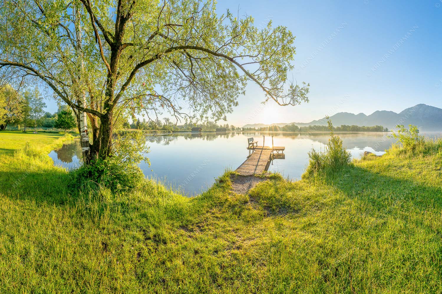 Blick über den Kochelsee bei Schlehdorf in den Sonnenaufgang - Die Sonne geht immer wieder auf III 3:2  -- Bootssteg mit Bank am Kochelsee - mehr Infos bei www.Kriner-Weiermann.de