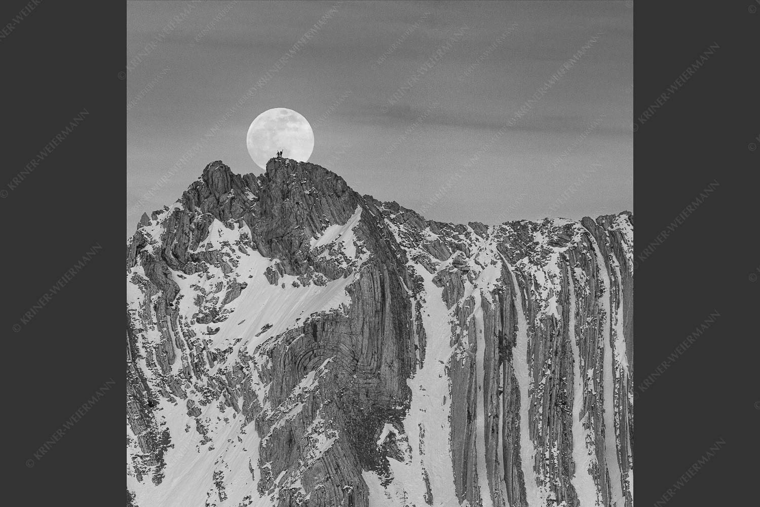 Der Vollmond wirkt riesig im Vergleich zu den beiden Menschen auf dem Gipfel - Verhältnis 1:1 sw -- Vollmond im Soierngebirge - mehr Infos bei www.Kriner-Weiermann.de