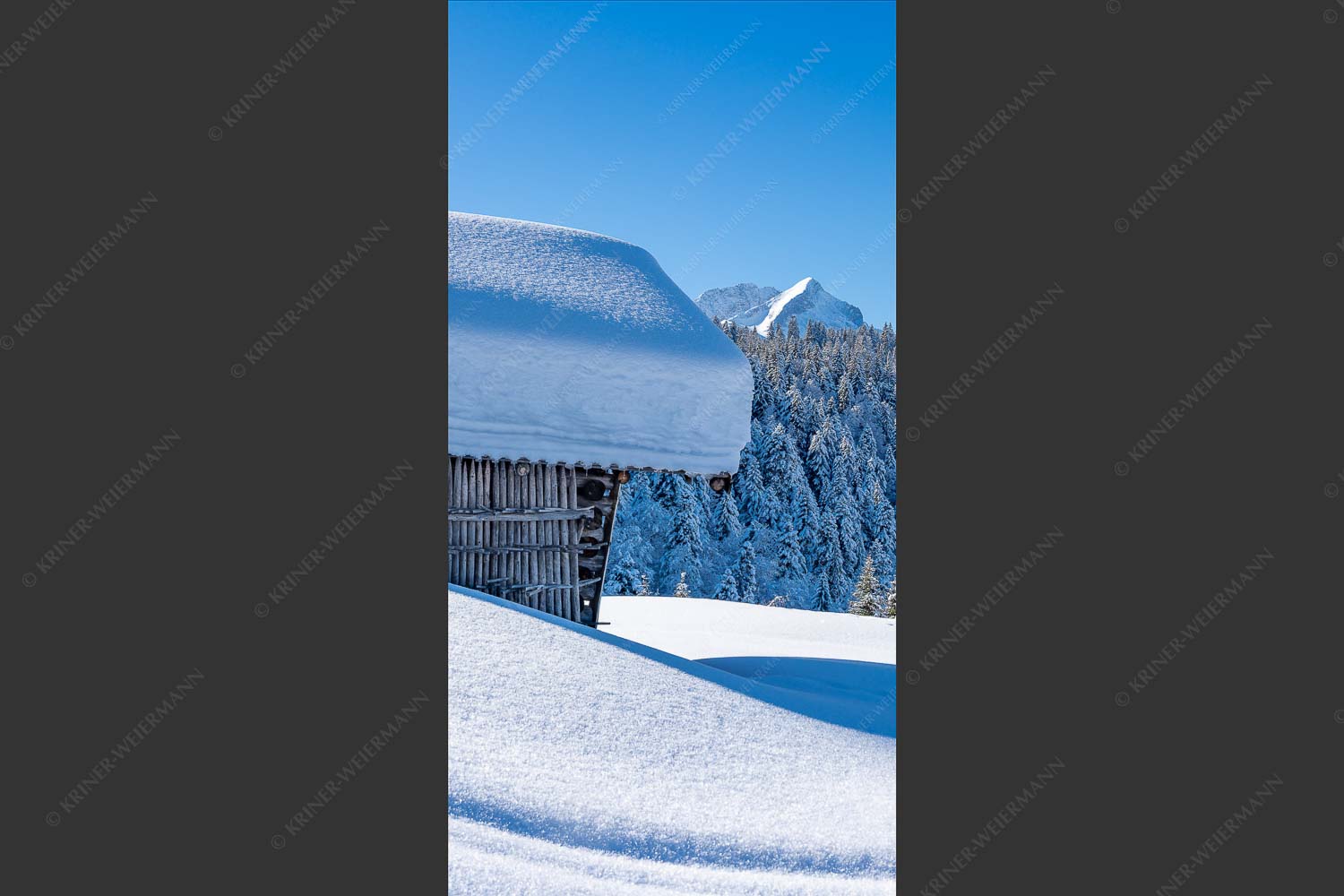 Wiesmahdstadel mit Stanker und viel Schnee mit Alpspitze, Zugspitze und Waxenstein im Hintergrund - Winter satt 1:2 -- viel Schnee Stadel mit Zugspitze - mehr Infos bei www.Kriner-Weiermann.de