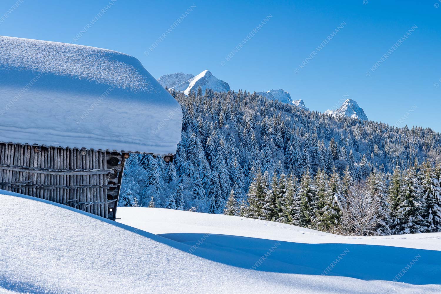 Wiesmahdstadel mit Stanker und viel Schnee mit Alpspitze, Zugspitze und Waxenstein im Hintergrund - Winter satt 3:2 -- viel Schnee Stadel mit Zugspitze - mehr Infos bei www.Kriner-Weiermann.de