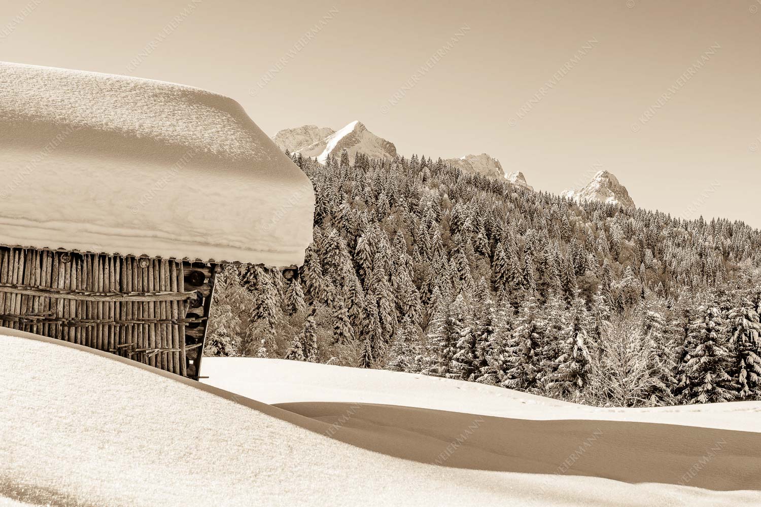 Wiesmahdstadel mit Stanker und viel Schnee mit Alpspitze, Zugspitze und Waxenstein im Hintergrund - Winter satt 3:2 sepia -- viel Schnee Stadel mit Zugspitze - mehr Infos bei www.Kriner-Weiermann.de