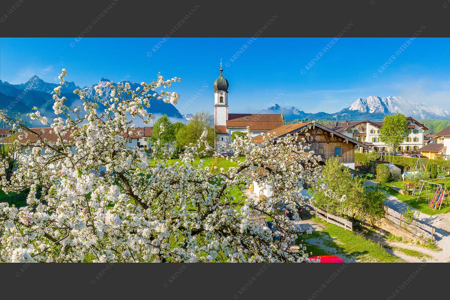 Kirche St. Sebastian in Krün mit Wetterstein- und Karwendelgebirge - Apfelblüte in Krün 2:1 -- Kirche in Krün Karwendel und Wetterstein - mehr Infos bei www.Kriner-Weiermann.de