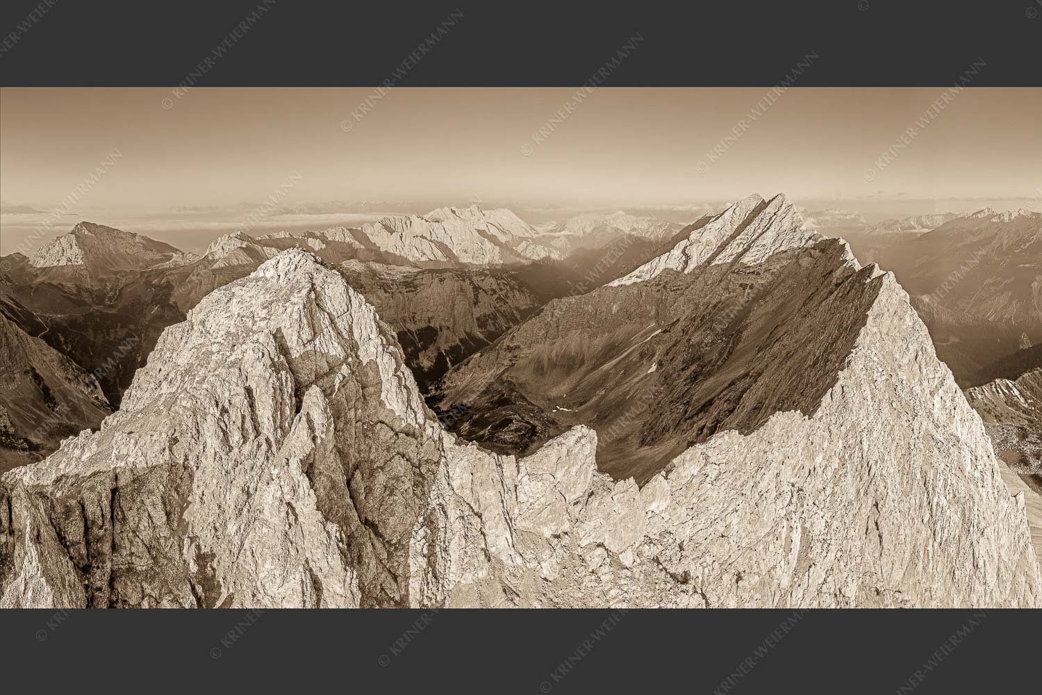 Bergsteiger auf dem Gipfel der Kaskarspitze blickt ins Karwendelgebirge - Der Mensch ist klein 2:1 sepia -- Kaskarspitze im Karwendel - mehr Infos bei www.Kriner-Weiermann.de