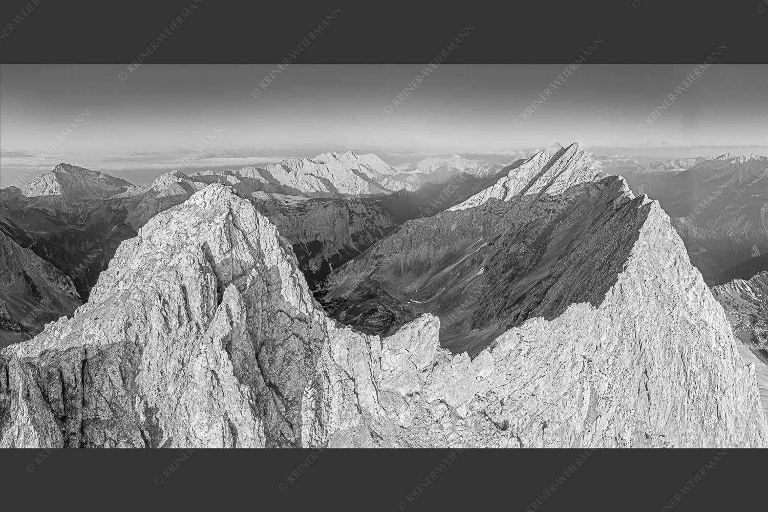 Bergsteiger auf dem Gipfel der Kaskarspitze blickt ins Karwendelgebirge - Der Mensch ist klein 2:1 sw -- Kaskarspitze im Karwendel - mehr Infos bei www.Kriner-Weiermann.de