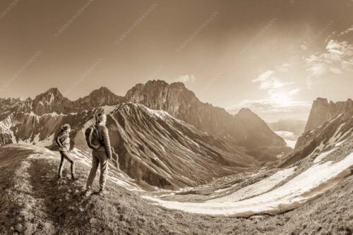 Blick durchs Puittal im Wetterstein in den Sonnenaufgang - Erlebnis Wetterstein 3:2 sepia -- Wanderer am Scharnitzjoch - mehr Infos bei www.Kriner-Weiermann.de