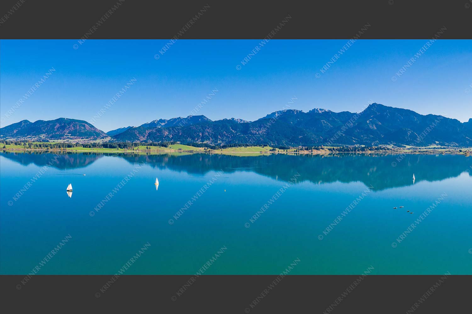 Blick über Forggensee ins Ammergebirge - Forggensee Segler 2:1  -- Segelschiff auf Forggensee - mehr Infos bei www.Kriner-Weiermann.de