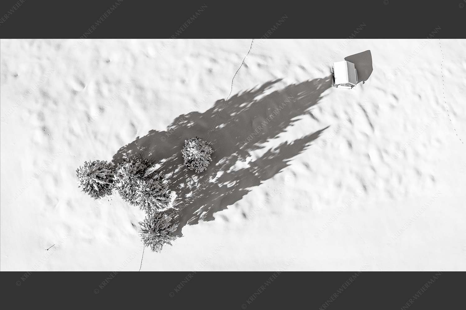 Blick auf eine Baumgruppe und Heustadel in Krün von Oben - Perspektive 2:1 sw -- Lange Schatten im Schnee - mehr Infos bei www.Kriner-Weiermann.de