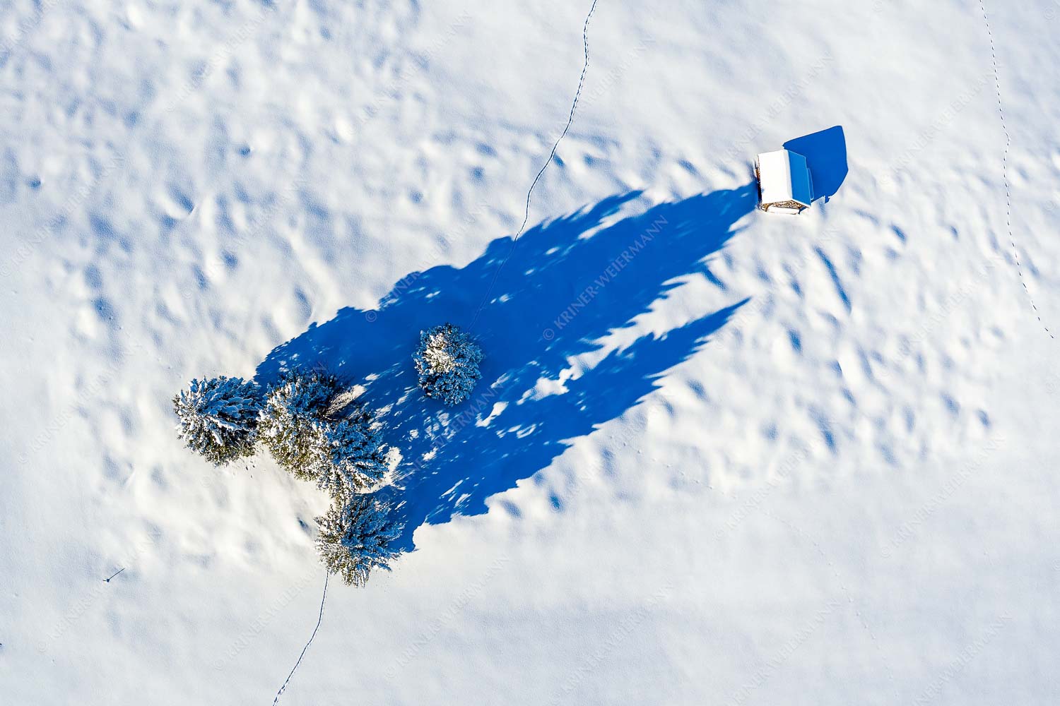 Blick auf eine Baumgruppe und Heustadel in Krün von Oben - Perspektive 3:2  -- Lange Schatten im Schnee - mehr Infos bei www.Kriner-Weiermann.de