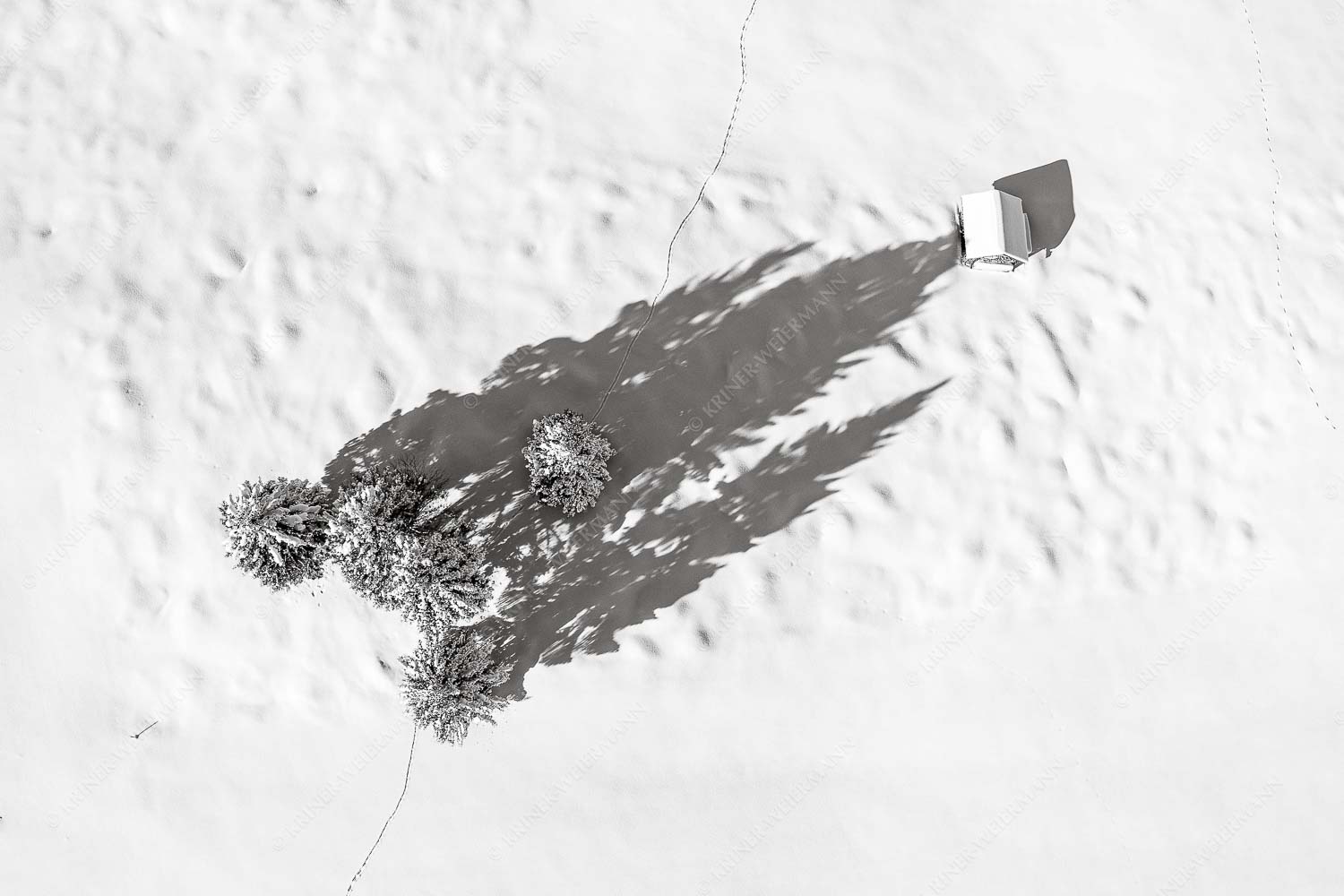 Blick auf eine Baumgruppe und Heustadel in Krün von Oben - Perspektive 3:2 sw -- Lange Schatten im Schnee - mehr Infos bei www.Kriner-Weiermann.de