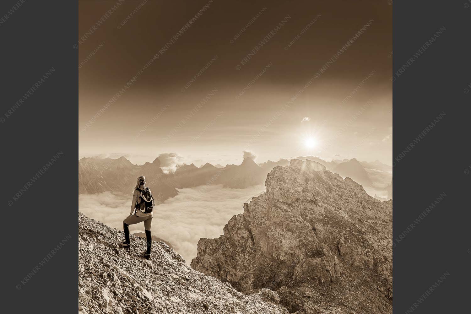 Blick von der Kaskarspitze im Karwendel über Nebelmeer in den Sonnenaufgang - Versteinert 1:1 sepia -- Bergsteigerin auf Kaskarspitze im Karwendel - mehr Infos bei www.Kriner-Weiermann.de