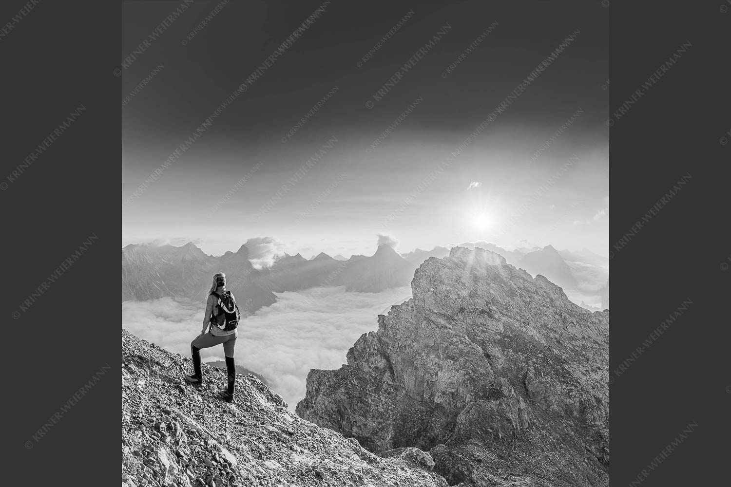 Blick von der Kaskarspitze im Karwendel über Nebelmeer in den Sonnenaufgang - Versteinert 1:1 sw -- Bergsteigerin auf Kaskarspitze im Karwendel - mehr Infos bei www.Kriner-Weiermann.de