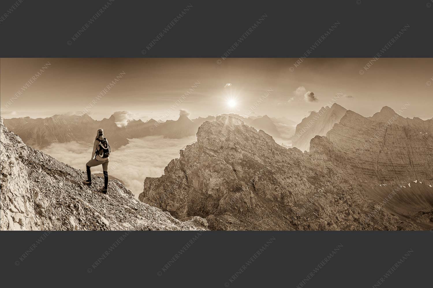 Blick von der Kaskarspitze im Karwendel über Nebelmeer in den Sonnenaufgang - Versteinert 2,5:1 sepia -- Bergsteigerin auf Kaskarspitze im Karwendel - mehr Infos bei www.Kriner-Weiermann.de