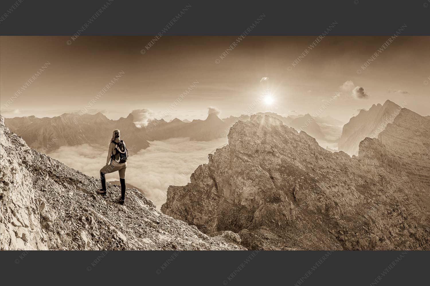 Blick von der Kaskarspitze im Karwendel über Nebelmeer in den Sonnenaufgang - Versteinert 2:1 sepia -- Bergsteigerin auf Kaskarspitze im Karwendel - mehr Infos bei www.Kriner-Weiermann.de