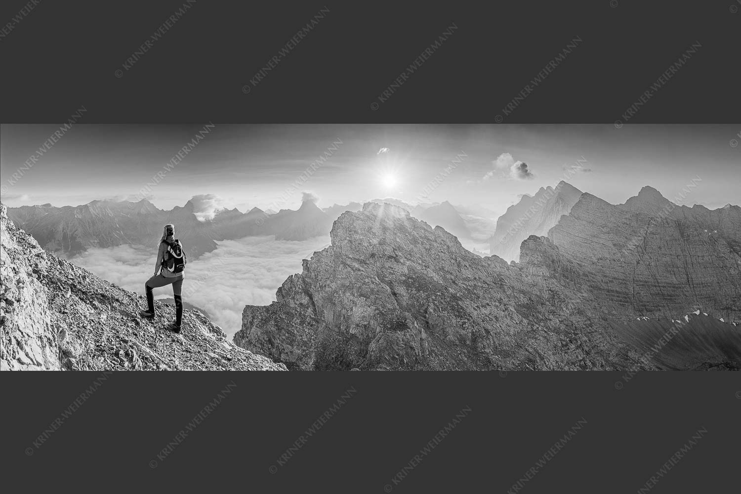 Blick von der Kaskarspitze im Karwendel über Nebelmeer in den Sonnenaufgang - Versteinert 3:1 sw -- Bergsteigerin auf Kaskarspitze im Karwendel - mehr Infos bei www.Kriner-Weiermann.de