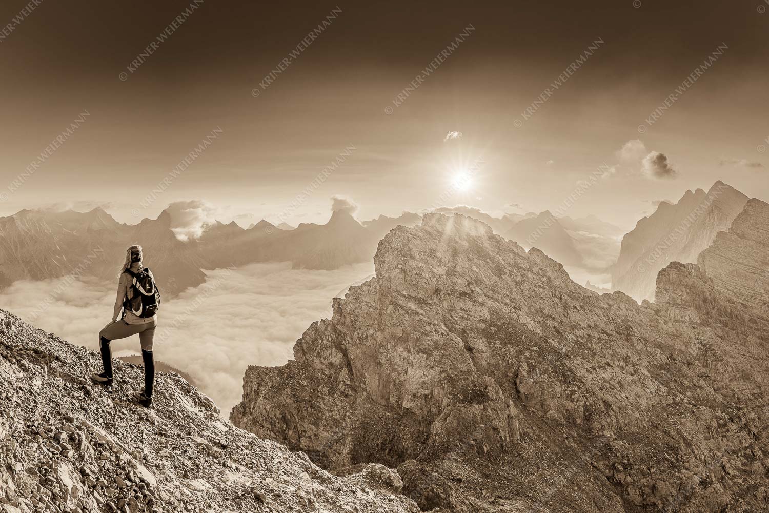 Blick von der Kaskarspitze im Karwendel über Nebelmeer in den Sonnenaufgang - Versteinert 3:2 sepia -- Bergsteigerin auf Kaskarspitze im Karwendel - mehr Infos bei www.Kriner-Weiermann.de