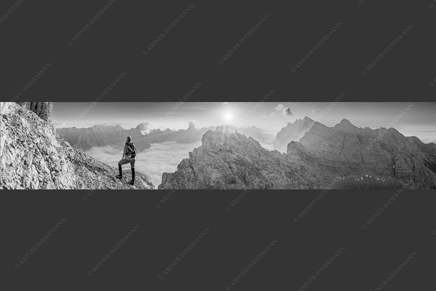 Blick von der Kaskarspitze im Karwendel über Nebelmeer in den Sonnenaufgang - Versteinert 5:1 sw -- Bergsteigerin auf Kaskarspitze im Karwendel - mehr Infos bei www.Kriner-Weiermann.de