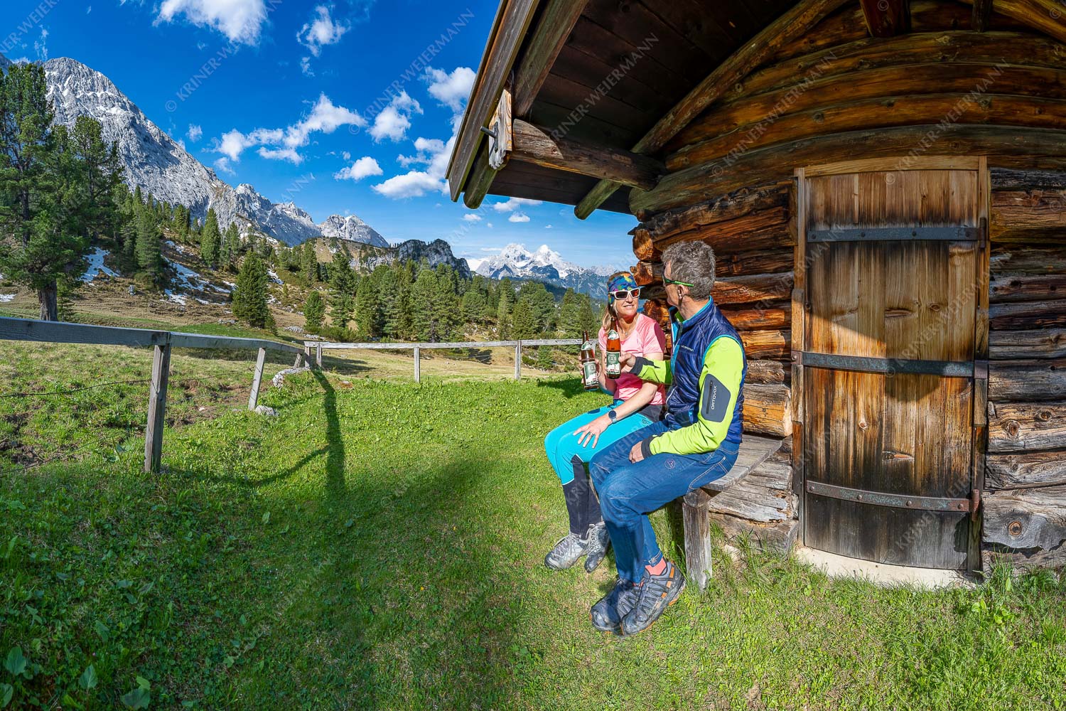 Mann und Frau trinken Bier an einer Berghütte - Bier auf der Hüttn II 3:2  -- Rast an einer Hütte - mehr Infos bei www.Kriner-Weiermann.de