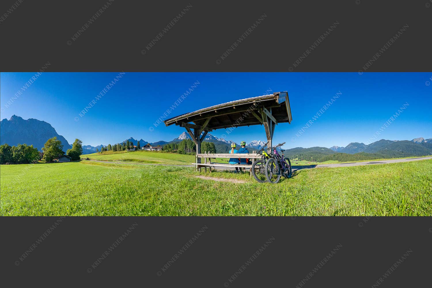 Rastbank am Tonihof mit Blick zum Wetterstein- und Estergebirge - Imposante Rast 3:1  -- Fahrradfahren in der Alpenwelt Karwendel - mehr Infos bei www.Kriner-Weiermann.de