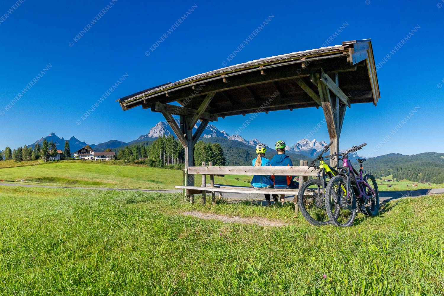 Rastbank am Tonihof mit Blick zum Wetterstein- und Estergebirge - Imposante Rast 3:2  -- Fahrradfahren in der Alpenwelt Karwendel - mehr Infos bei www.Kriner-Weiermann.de