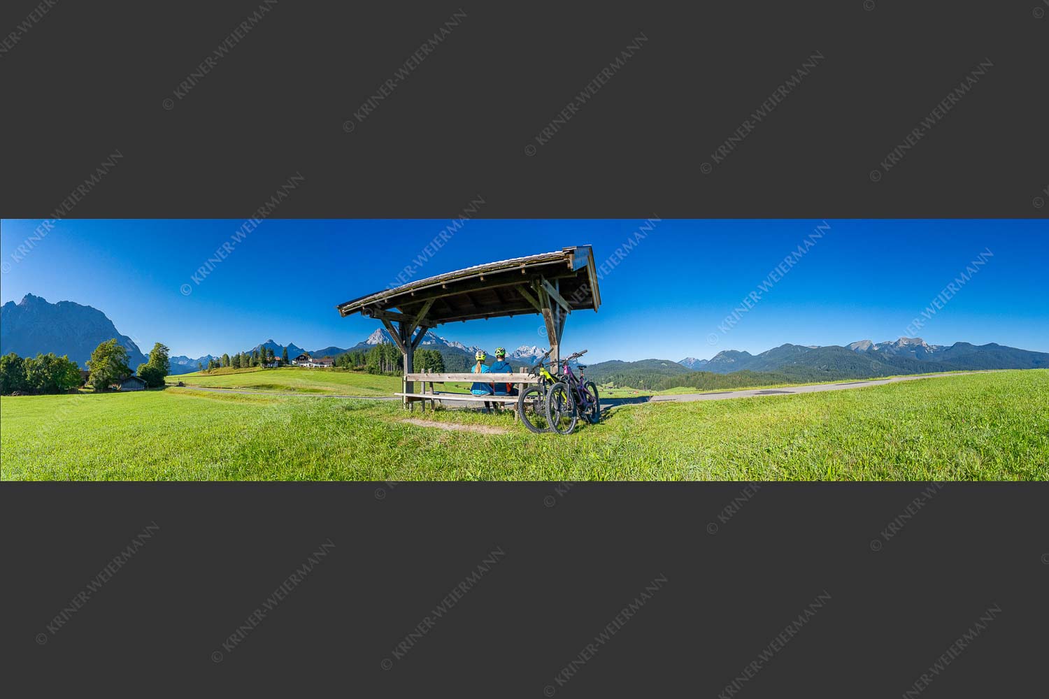 Rastbank am Tonihof mit Blick zum Wetterstein- und Estergebirge - Imposante Rast 4:1  -- Fahrradfahren in der Alpenwelt Karwendel - mehr Infos bei www.Kriner-Weiermann.de