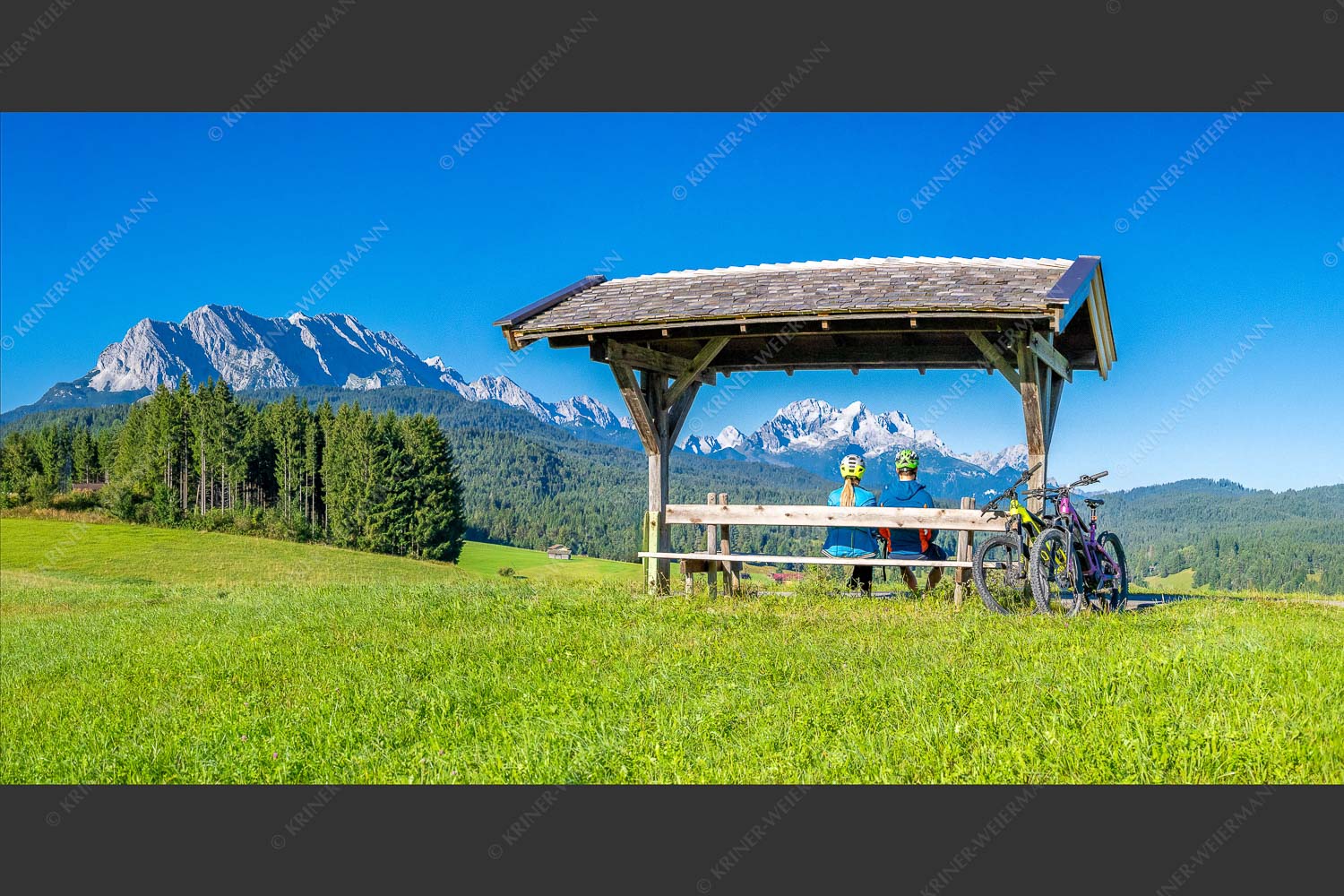 Rastbank am Tonihof mit Blick zum Wetterstein- und Estergebirge - Imposante Rast II 2:1  -- Fahrradfahren in der Alpenwelt Karwendel - mehr Infos bei www.Kriner-Weiermann.de