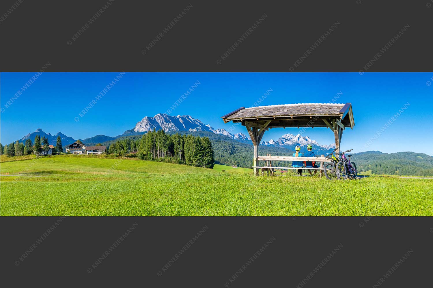 Rastbank am Tonihof mit Blick zum Wetterstein- und Estergebirge - Imposante Rast II 3:1  -- Fahrradfahren in der Alpenwelt Karwendel - mehr Infos bei www.Kriner-Weiermann.de