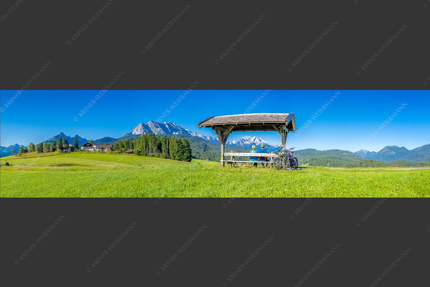 Rastbank am Tonihof mit Blick zum Wetterstein- und Estergebirge - Imposante Rast II 4:1  -- Fahrradfahren in der Alpenwelt Karwendel - mehr Infos bei www.Kriner-Weiermann.de