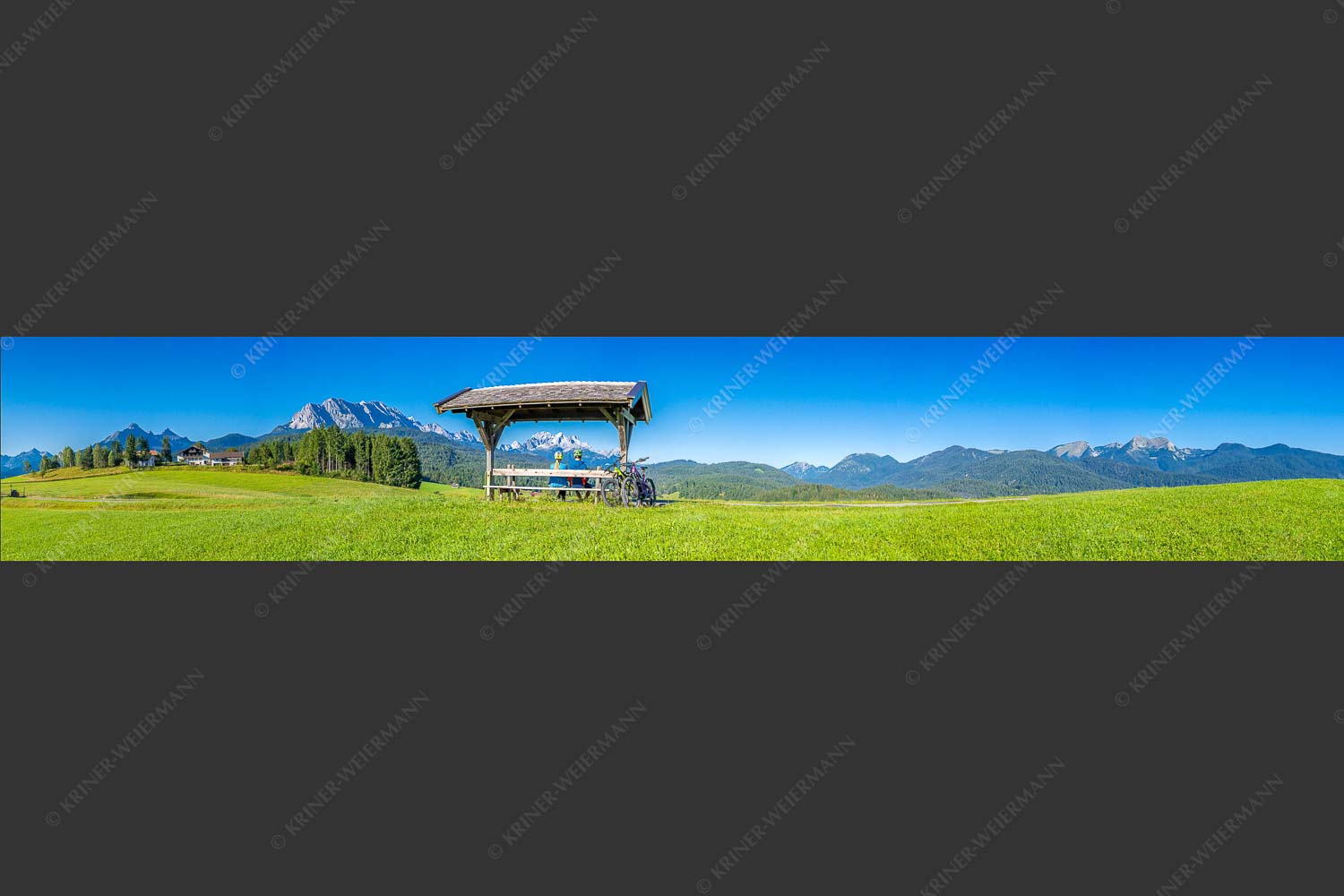 Rastbank am Tonihof mit Blick zum Wetterstein- und Estergebirge - Imposante Rast II 6:1  -- Fahrradfahren in der Alpenwelt Karwendel - mehr Infos bei www.Kriner-Weiermann.de