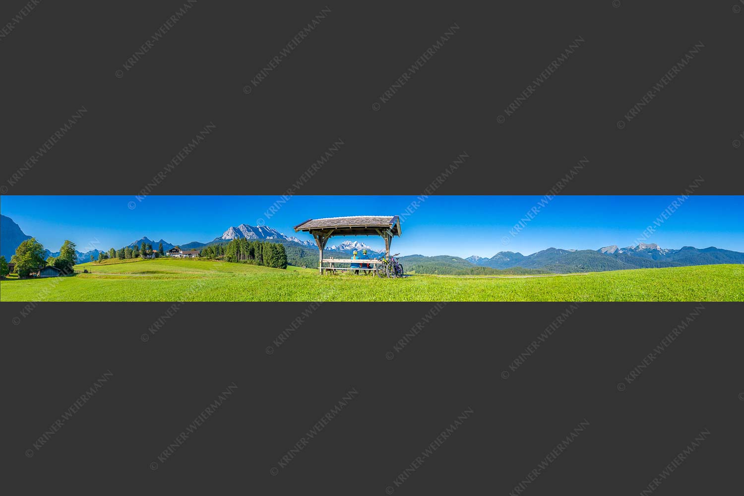 Rastbank am Tonihof mit Blick zum Wetterstein- und Estergebirge - Imposante Rast II 7:1  -- Fahrradfahren in der Alpenwelt Karwendel - mehr Infos bei www.Kriner-Weiermann.de