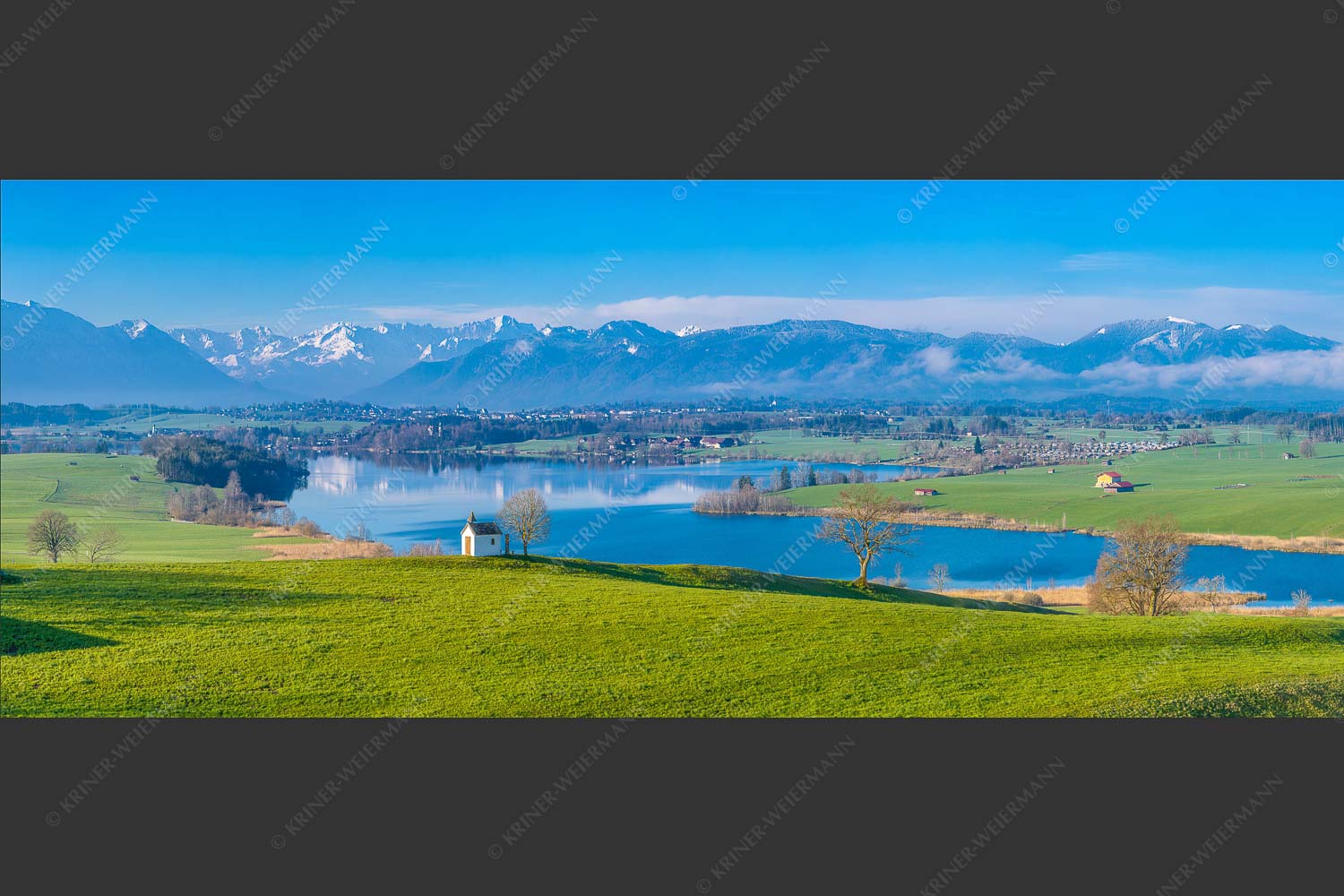 Blick über den Riegsee zum Estergebirge, Wetterstein und Ammergauer Bergen - Frühlingsgöttin Ostara 2,5:1  -- Mesnerhauskapelle Aidling - mehr Infos bei www.Kriner-Weiermann.de