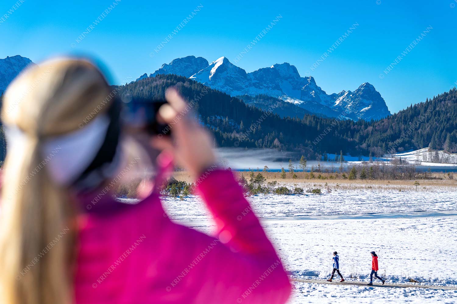 Frau fotografiert Wanderere am Barmsee beim Spaziergang - Winterfotografie1 3:2  -- Spazieren am Barmsee - mehr Infos bei www.Kriner-Weiermann.de